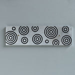 Magnetic Key Holder in brushed aluminum and black with circles.