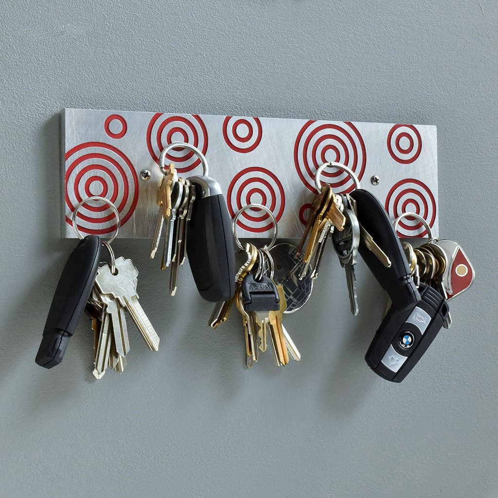 Magnetic Key Holder in brushed aluminum and red with circles.