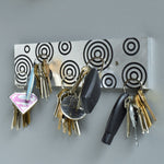 Magnetic Key Holder in brushed aluminum and black with circles.