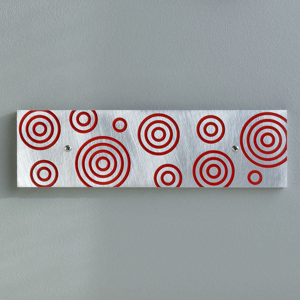 Magnetic Key Holder in brushed aluminum and red with circles.