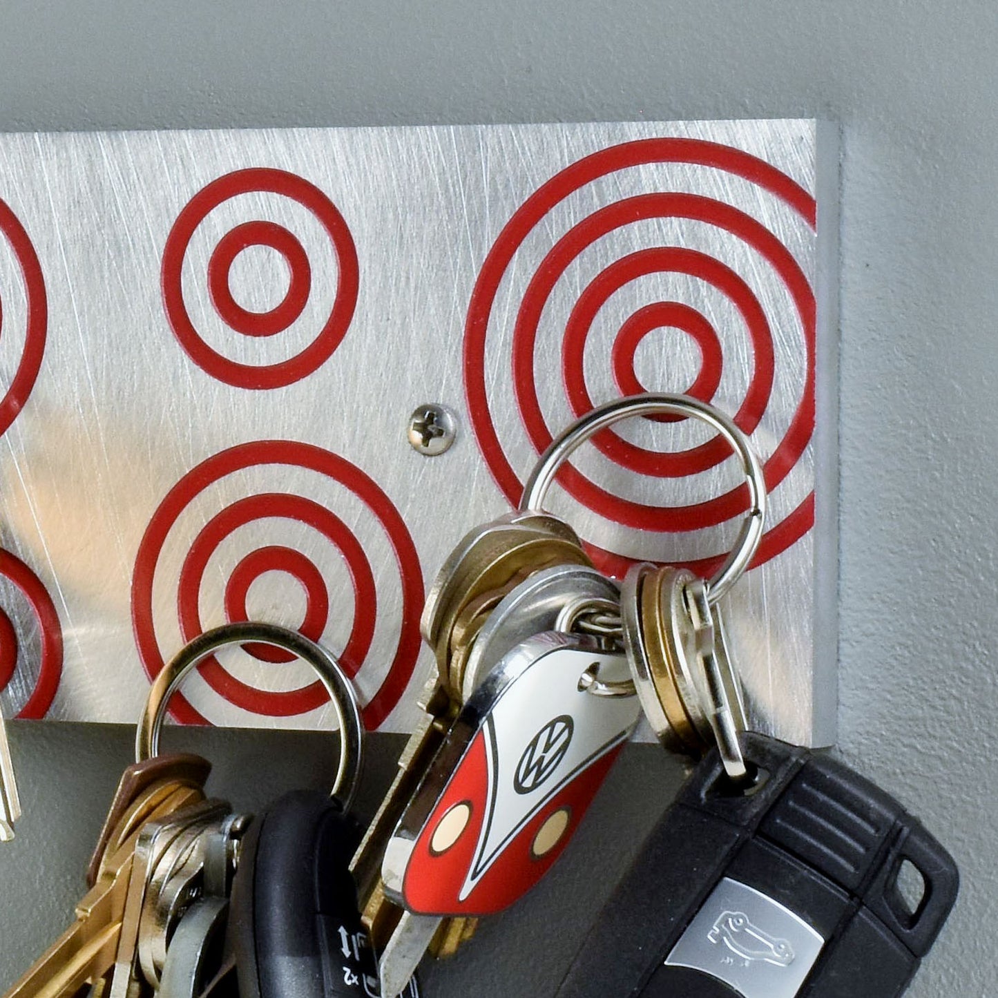 Magnetic Key Holder in brushed aluminum and red with circles.